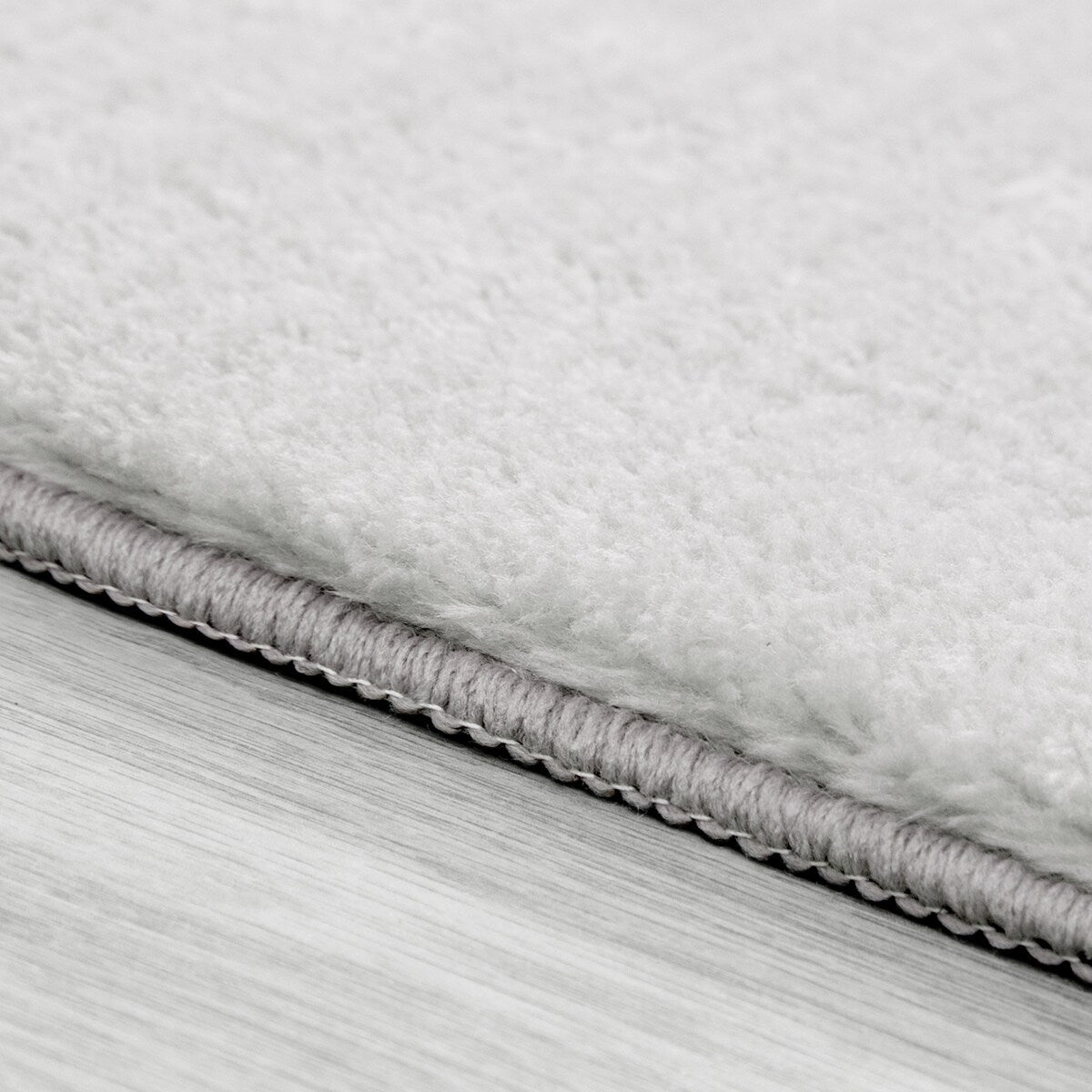 Tapis doux et lavable avec envers antidérapant, disponible en couleurs unies.